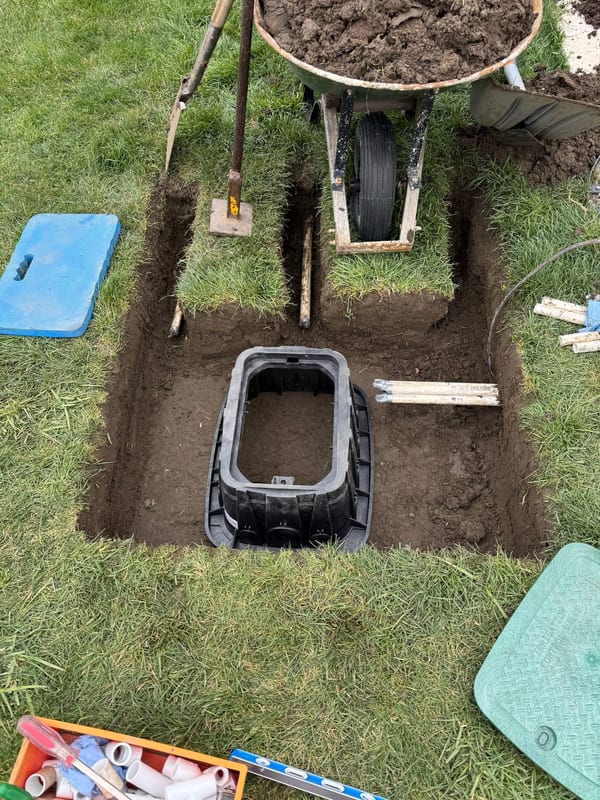 New sprinkler valve box set level in an excavated hole