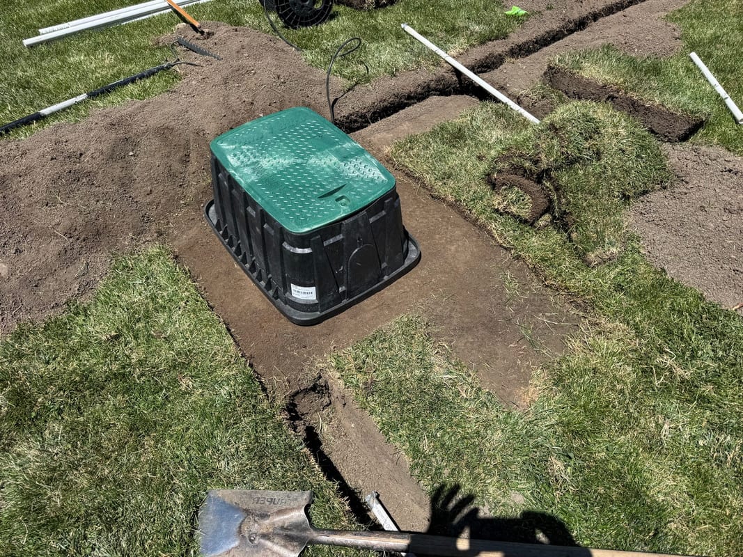 Green valve box set where several sprinkler trenches meet
