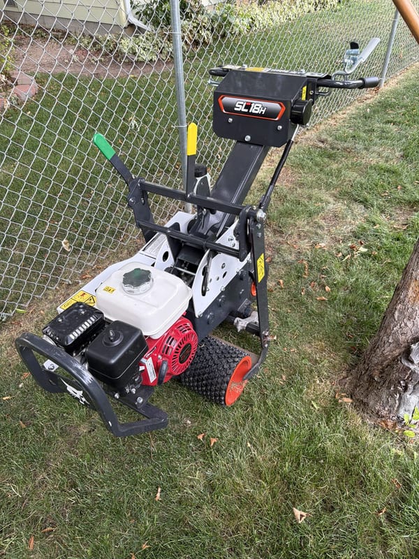 Gas-powered sod cutter in a fenced yard