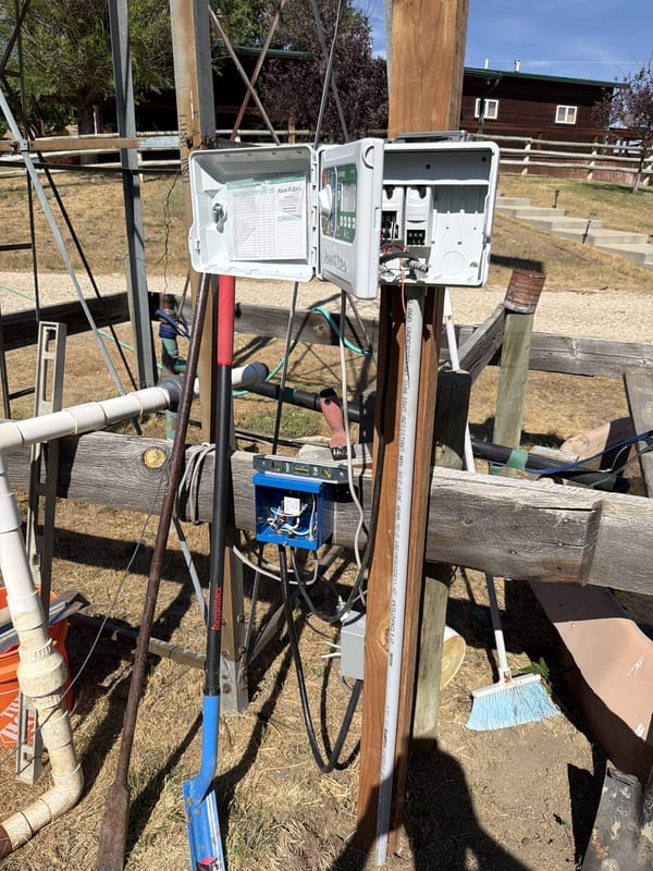 Irrigation controller and pump control box mounted on a wooden post
