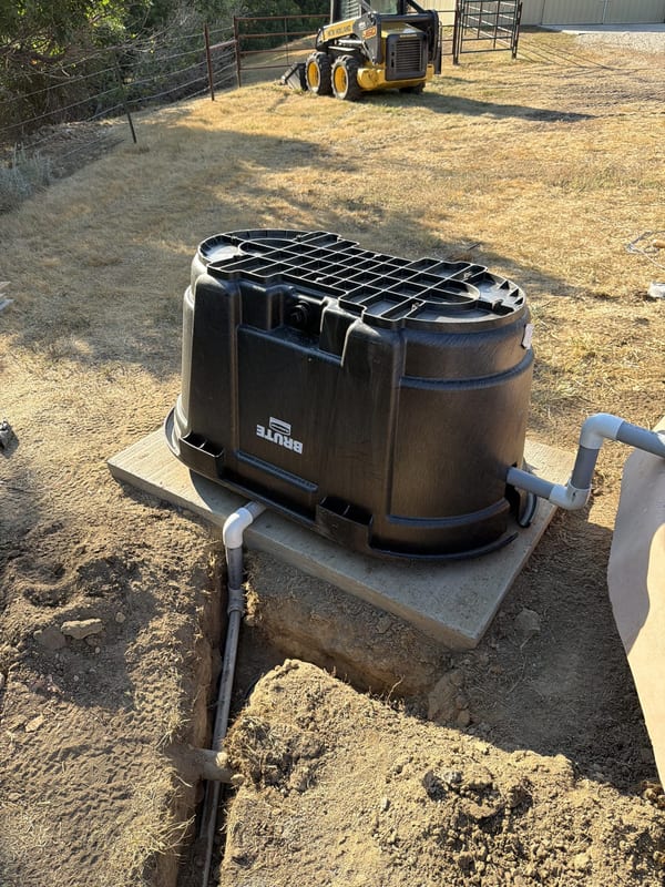 Black protective pump enclosure on a concrete pad