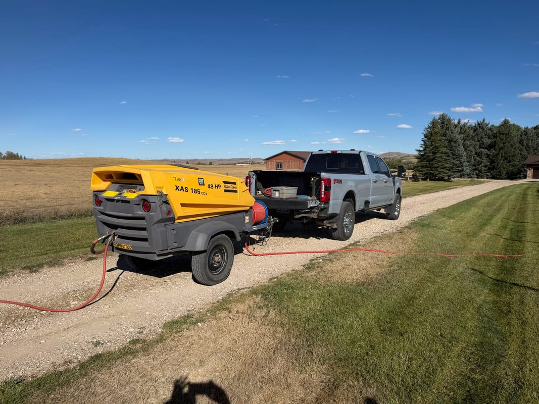 Towable air compressor hitched to a pickup for sprinkler winterization