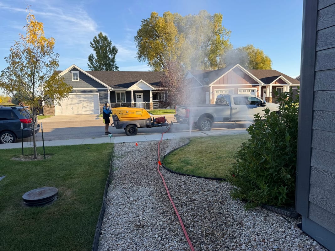 Air compressor connected to a home sprinkler system during a fall blowout